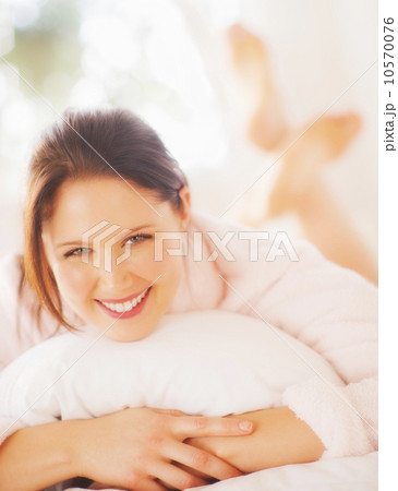 Portrait of young woman lying on bed Portrait of young woman lying on bed 10570076
