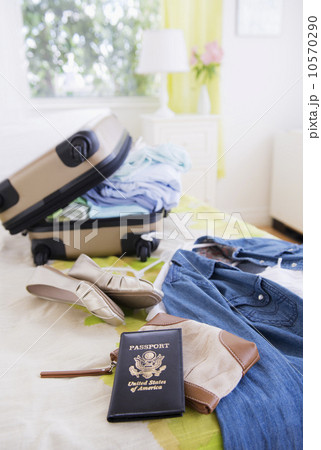 Suitcase and passport on bed during packing 10570290