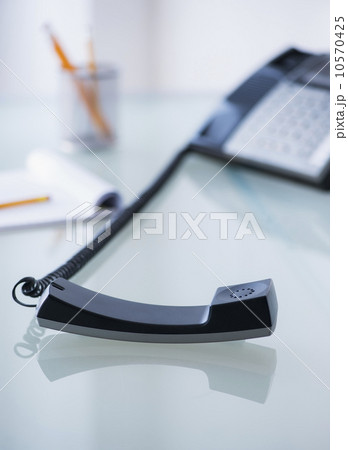 View of telephone and paper material on desk View of telephone and paper material on desk 10570425