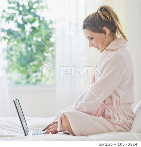 Portrait of young woman with laptop in bedroom 10570524