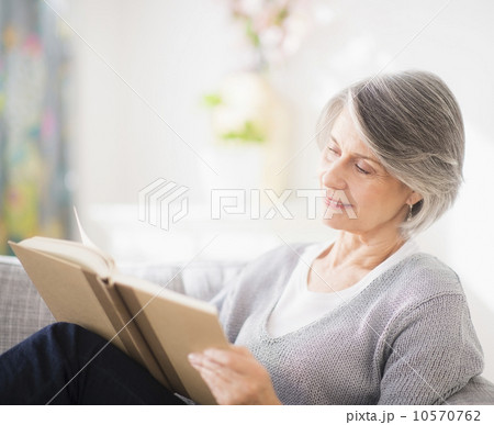 Portrait of woman reading on sofa 10570762