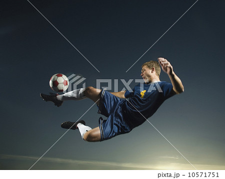 Man kicking soccer ball in air 10571751