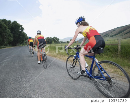 Cyclists in a row on country road 10571789