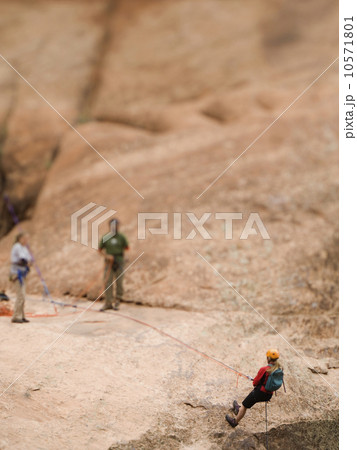 Woman in rappelling gear at top of cliff 10571801