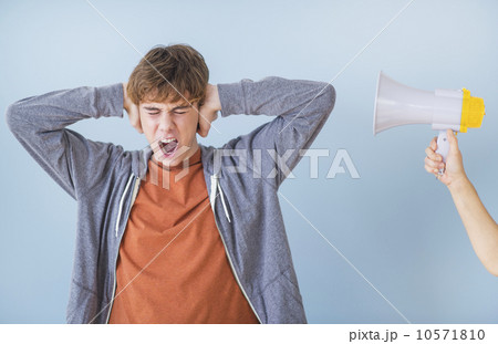 Teenage boy (14-15) with hands on ears Teenage boy (14-15) with hands on ears 10571810