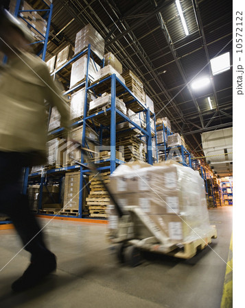 Warehouse worker pulling palette Warehouse worker pulling palette 10572122