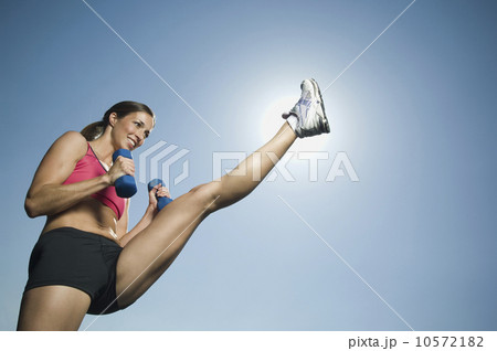 Woman in athletic gear kicking 10572182