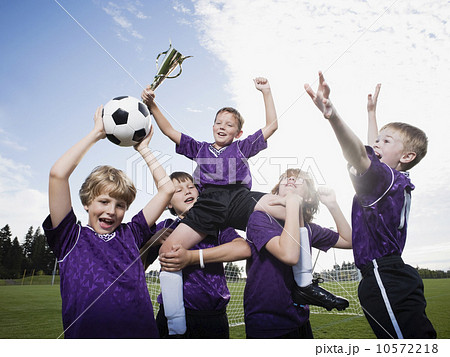 Boys soccer team celebrating with trophy 10572218