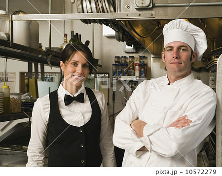 Chef and waitress posing in restaurant kitchen Chef and waitress posing in restaurant kitchen 10572279