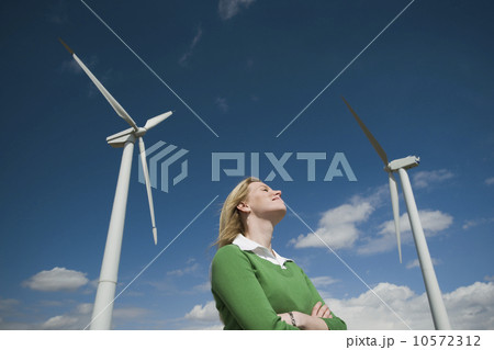 Low angle view of woman and wind turbines Low angle view of woman and wind turbines 10572312