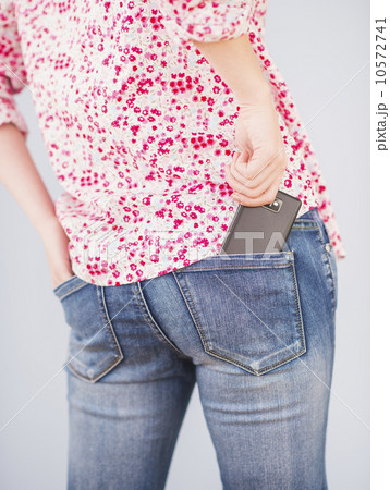 Rear view of woman with hand in pocket and mobile phone Rear view of woman with hand in pocket and mobile phone 10572741