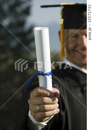 Male graduate holding diploma Male graduate holding diploma 10572742