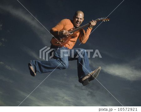Man playing guitar and jumping Man playing guitar and jumping 10572921