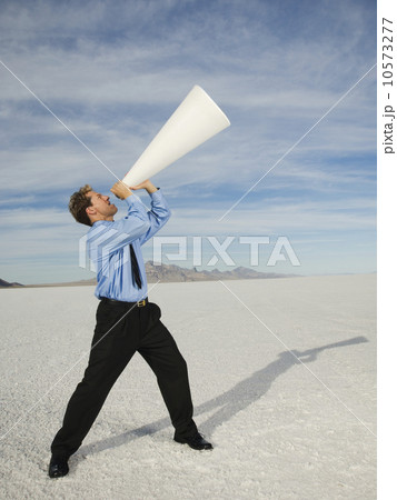 Businessman yelling into megaphone, Salt Flats, Utah, United States 10573277