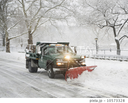 Snow plow truck clearing road 10573328