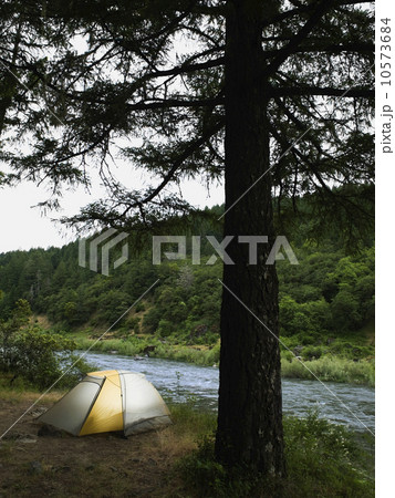Tent and campsite by river 10573684