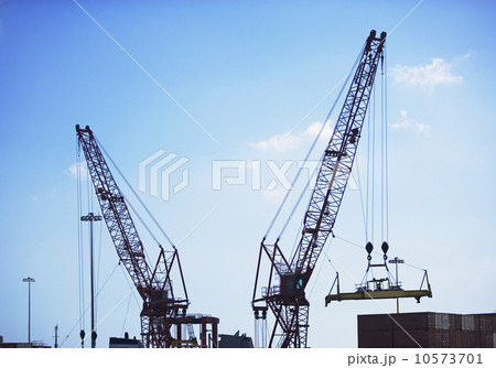 Cranes moving shipping containers 10573701