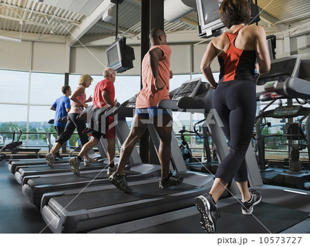 Men and women running on treadmills Men and women running on treadmills 10573727