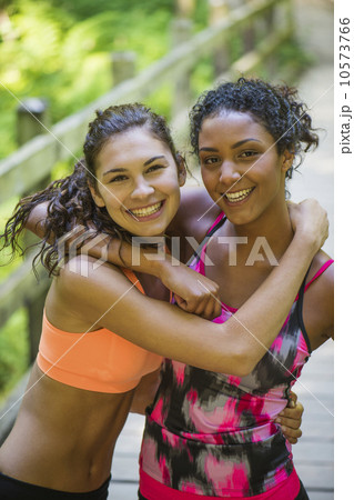 Two young women in sports clothing embracing 10573766