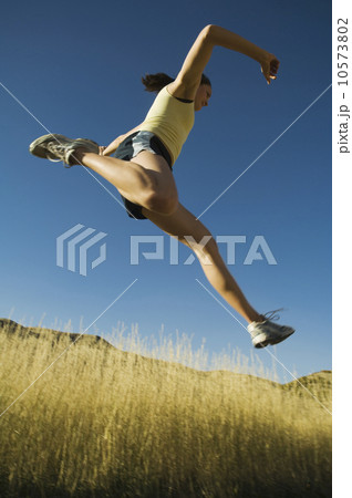 Low angle view of woman jumping, Salt Flats, Utah, United States 10573802