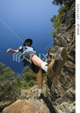Hiker stepping down rocky trail 10574151