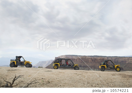 People in off-road vehicles on rock formation 10574221
