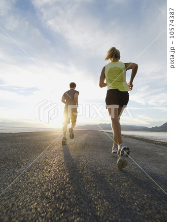 Couple running on road, Utah, United States 10574387