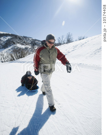 Father pulling children on sled 10574408