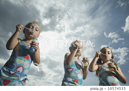 Three young sisters blowing bubbles Three young sisters blowing bubbles 10574535