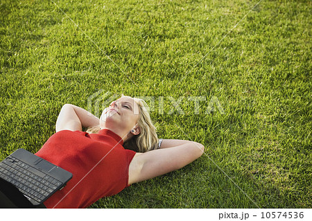 Woman lying on grass with laptop Woman lying on grass with laptop 10574536