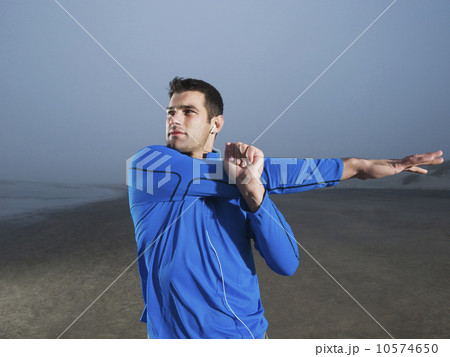 Man stretching on beach Man stretching on beach 10574650