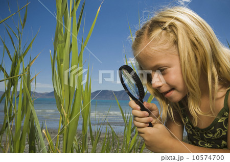 Girl looking through magnifying glass, Utah, United States Girl looking through magnifying glass, Utah, United States 10574700