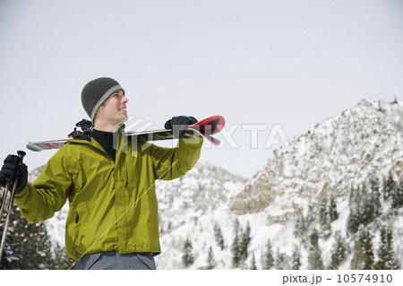 A downhill skier carrying skis A downhill skier carrying skis 10574910