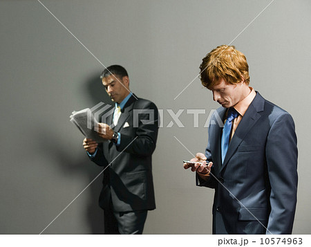 Businessmen holding newspaper and cell phone Businessmen holding newspaper and cell phone 10574963