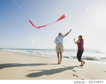 Couple flying kite on beach Couple flying kite on beach 10574974