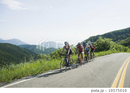Cyclists in a row on mountain road Cyclists in a row on mountain road 10575010