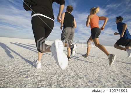 Group of people running on salt flats, Utah, United States 10575301