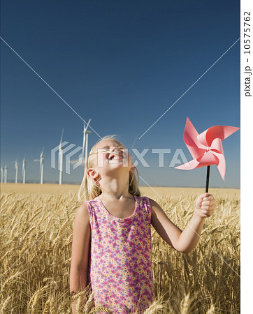 Smiling girl holding pinwheel on wind farm 10575762