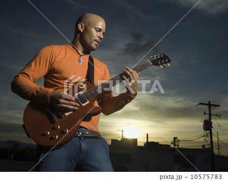 Man playing guitar at dusk 10575783