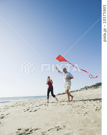 Couple flying kite on beach Couple flying kite on beach 10575905