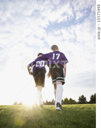 Boys in soccer uniforms walking on field 10575998