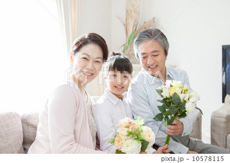 孫からお花をもらう老夫婦 10578115
