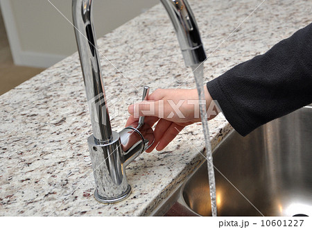 Woman turns on tap water 10601227