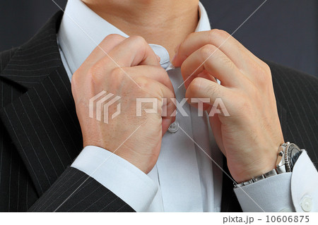 young man adjusting his suit on a black background 10606875