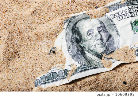 100 dollar bill buried in the sand 10609395