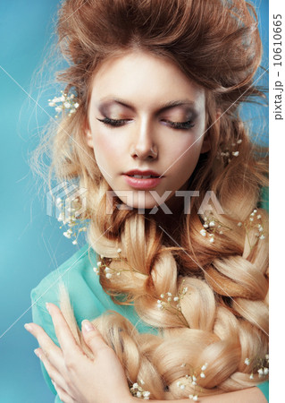 Enjoyment. Woman with Plait and Intertwined Flowers 10610665