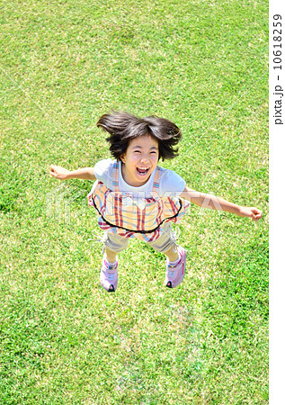芝生広場でジャンプする女の子 10618259