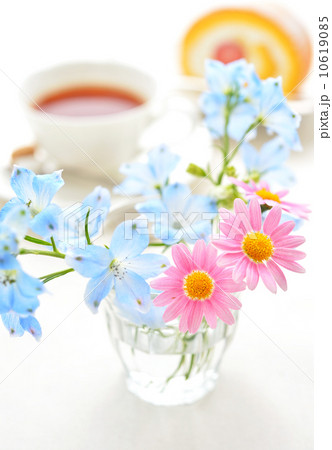 ロールケーキと紅茶とかわいいお花 の写真素材