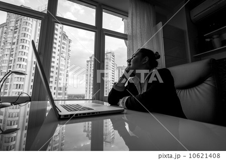 dreamy businesswoman looking out of window in office dreamy businesswoman looking out of window in office 10621408