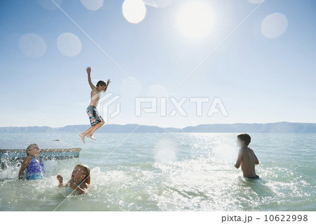 Kids (6-7,8-9,10-11,12-13) playing on raft on lake 10622998